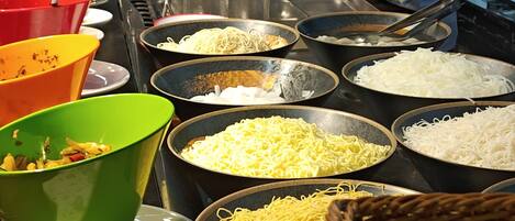 A buffet setup with various dishes and utensils.