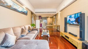 Una sala de estar moderna con un sofá, una mesa de centro y un televisor sobre un mueble.