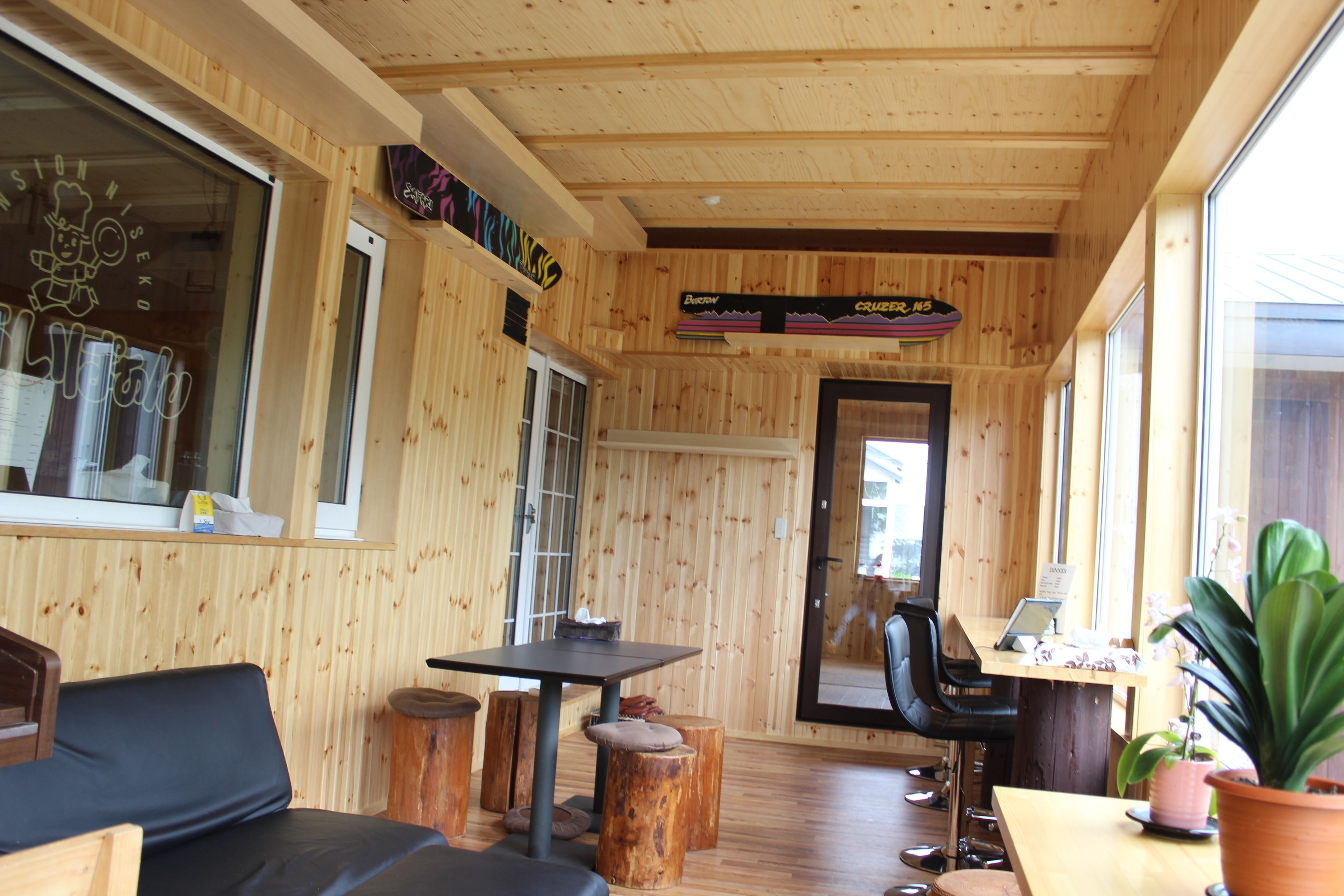 Un interior de madera con una zona de estar, una mesa y una planta en maceta.