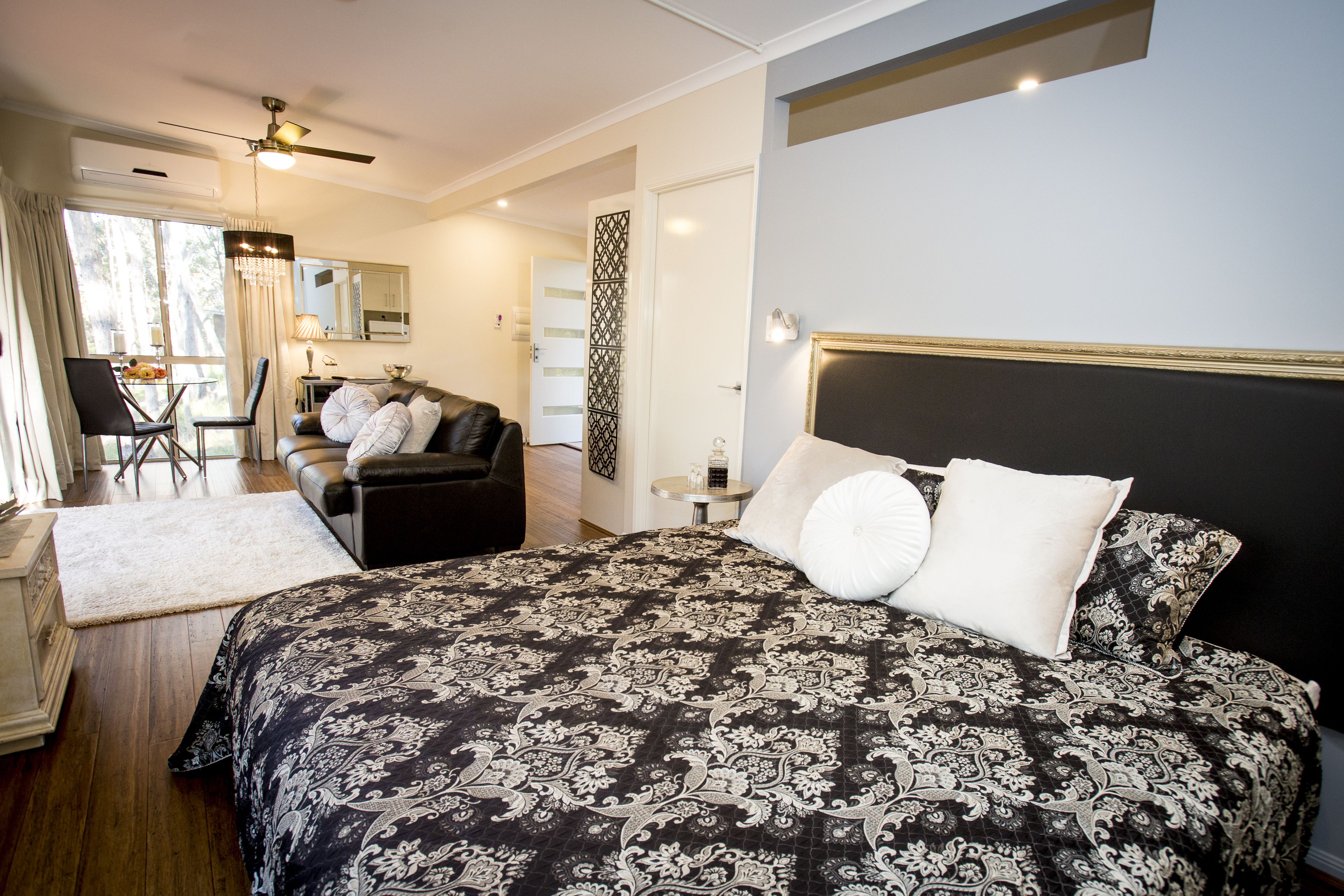 A bedroom with a large bed, a desk, and a chair.