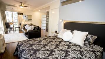 A bedroom with a large bed, a desk, and a chair.