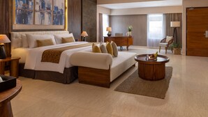 Une chambre d’hôtel avec un grand lit, un bureau, une chaise et une table basse.