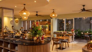 Une cuisine moderne dotée d’un îlot central, de meubles en bois et d’un coin repas avec une table ronde et des chaises.