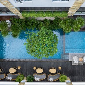 Una piscina al aire libre, sillones reclinables de piscina