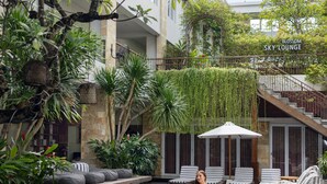 Un espace piscine avec des chaises longues, un escalier et de la verdure.