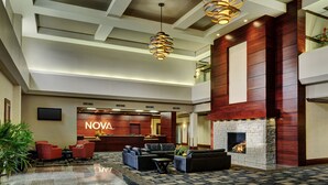 A lobby with a reception desk, seating area, and a fireplace. - Chateau Nova Yellowhead (Edmonton)