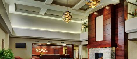A lobby with a reception desk, seating area, and a fireplace.