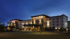 A hotel with a 'NOW OPEN' sign, multiple floors, and a 'CONFERENCE' sign indicating a business center. - Chateau Nova Yellowhead (Edmonton)