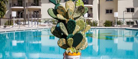 Una piscina techada, una piscina al aire libre de temporada, sombrillas