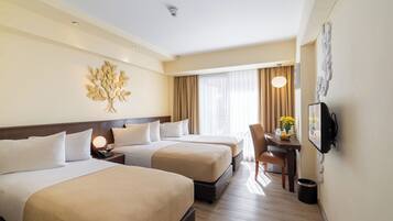 Une chambre d’hôtel avec deux lits, un bureau avec une chaise, une télévision et un élément décoratif mural.