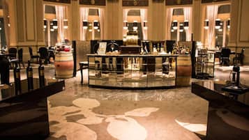 A bar area with a central bar counter, multiple seating arrangements, and decorative elements like a barrel and a chandelier.