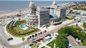 Un grand bâtiment historique doté de deux dômes, d’une cour intérieure et d’une piscine.