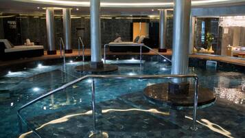 Relax by the pool surrounded by elegant columns and plush loungers.