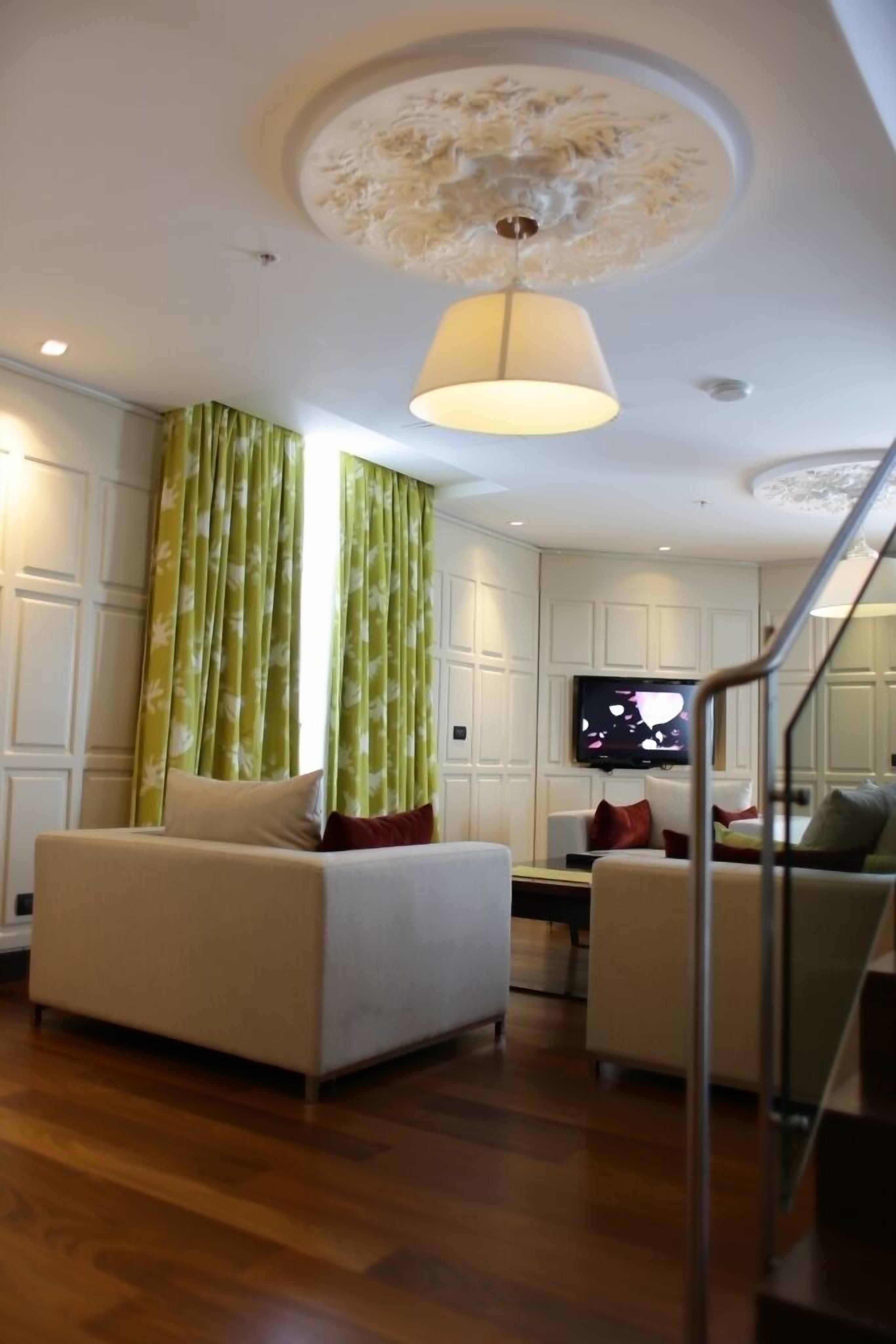 Una sala de estar moderna con un sofá, un televisor y una escalera.
