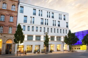 Un edificio moderno con diversi piani, ampie finestre e un cartello con su scritto 