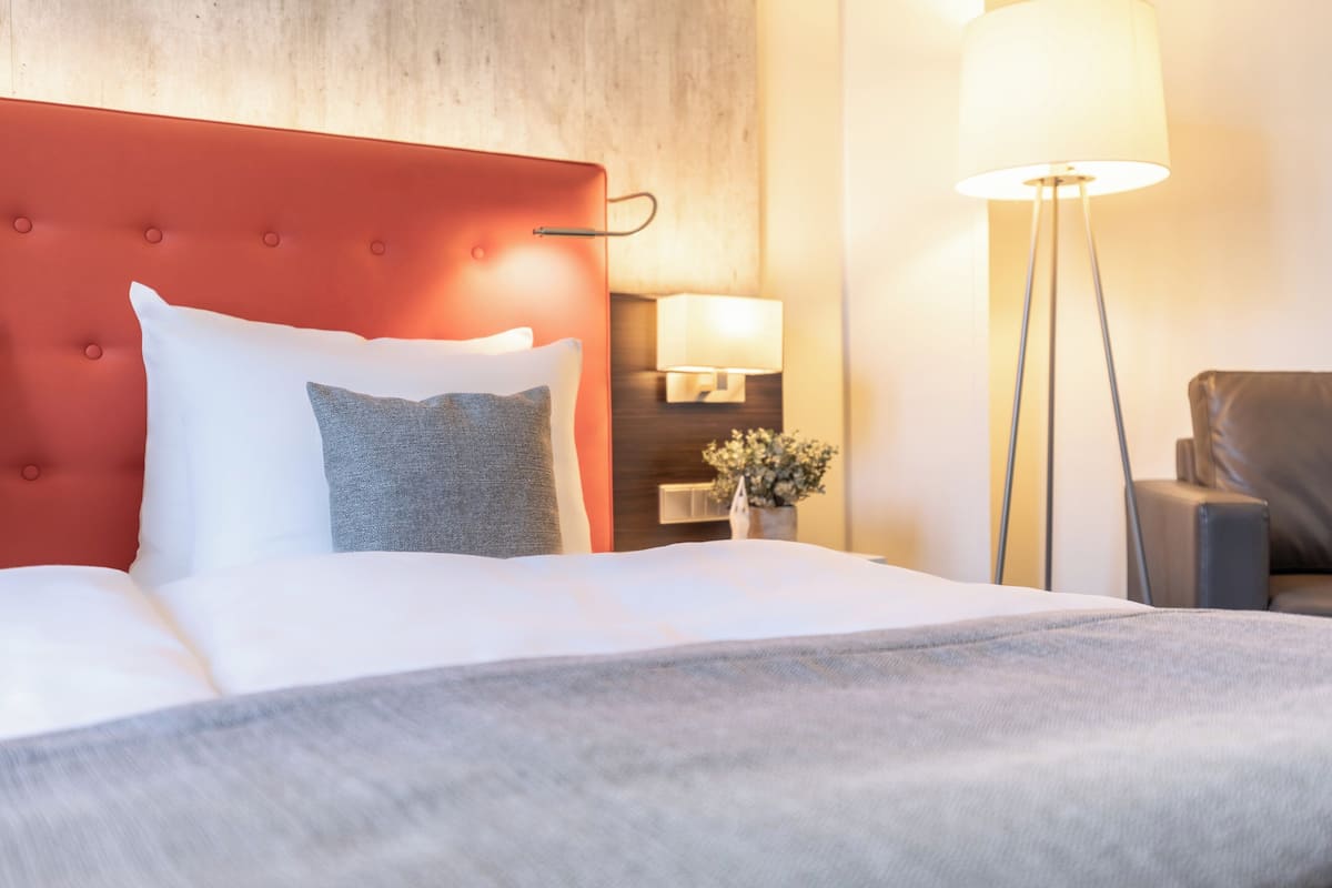 Ropa de cama hipoalergénica y caja de seguridad en la habitación