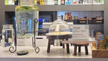 A bar area with a variety of liquor bottles, a large glass jar with a lid, and a display of local biscuits.