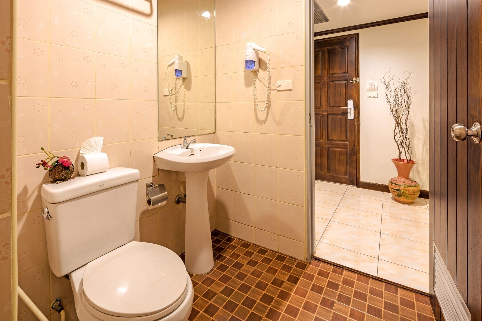 A bathroom with a toilet, sink, and a shower area.