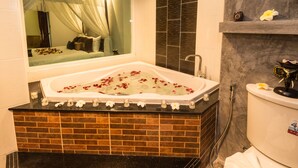 A bathroom with a large bathtub, a shower, and a toilet. - Tanawan Phuket Hotel (Patong)