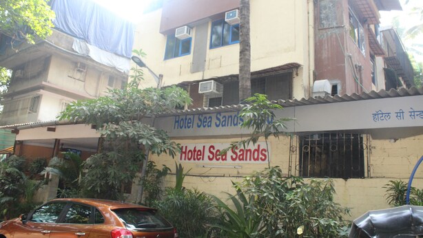 Un immeuble sur lequel on peut lire l’inscription : « Hôtel Sea Sands ».