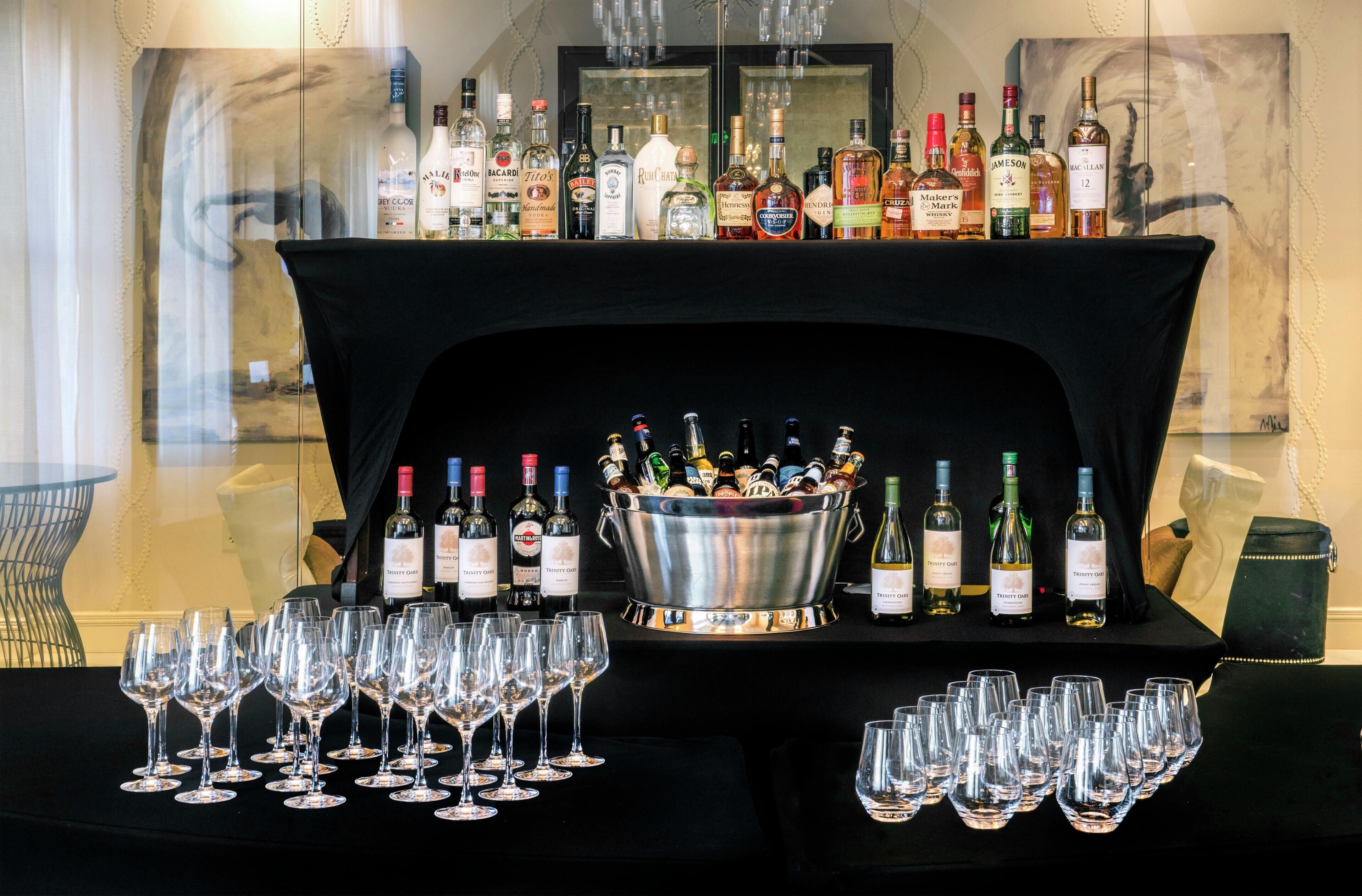 A bar area with a variety of liquor bottles and glasses.