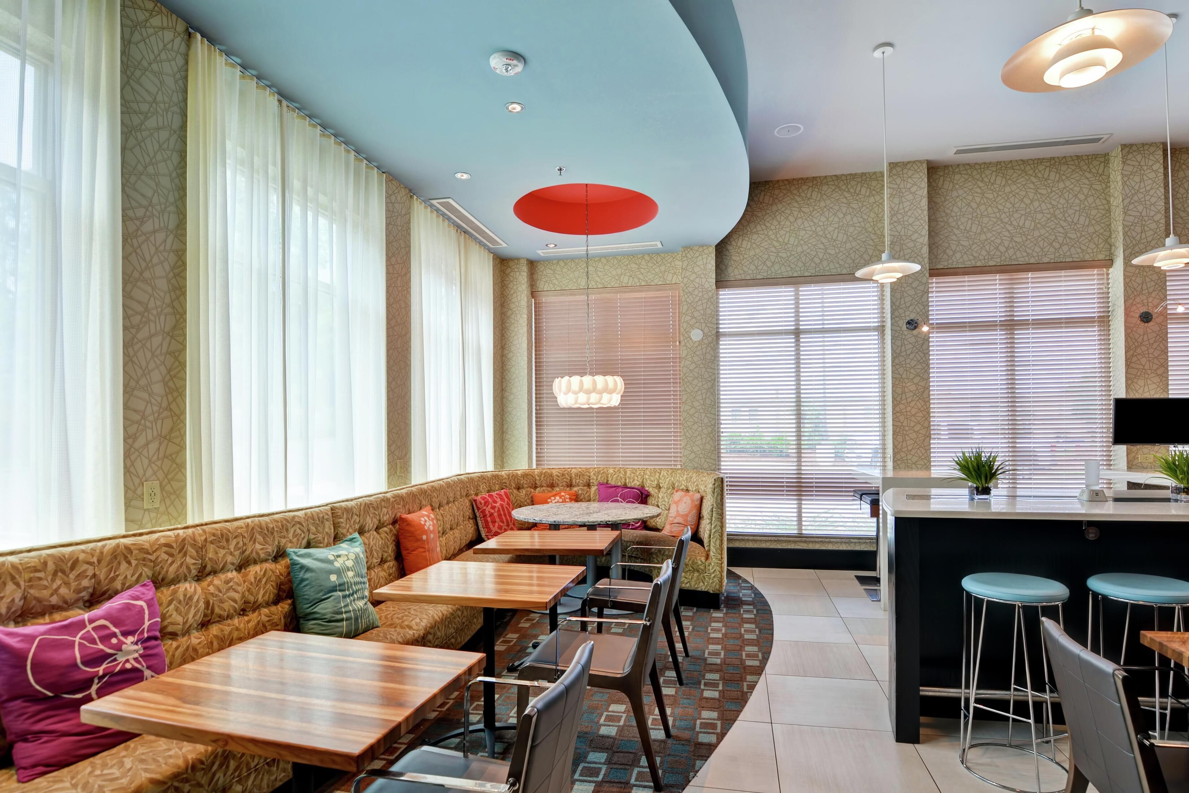 Un restaurante con techo curvo, una zona de bar y una disposición de mesas y sillas.