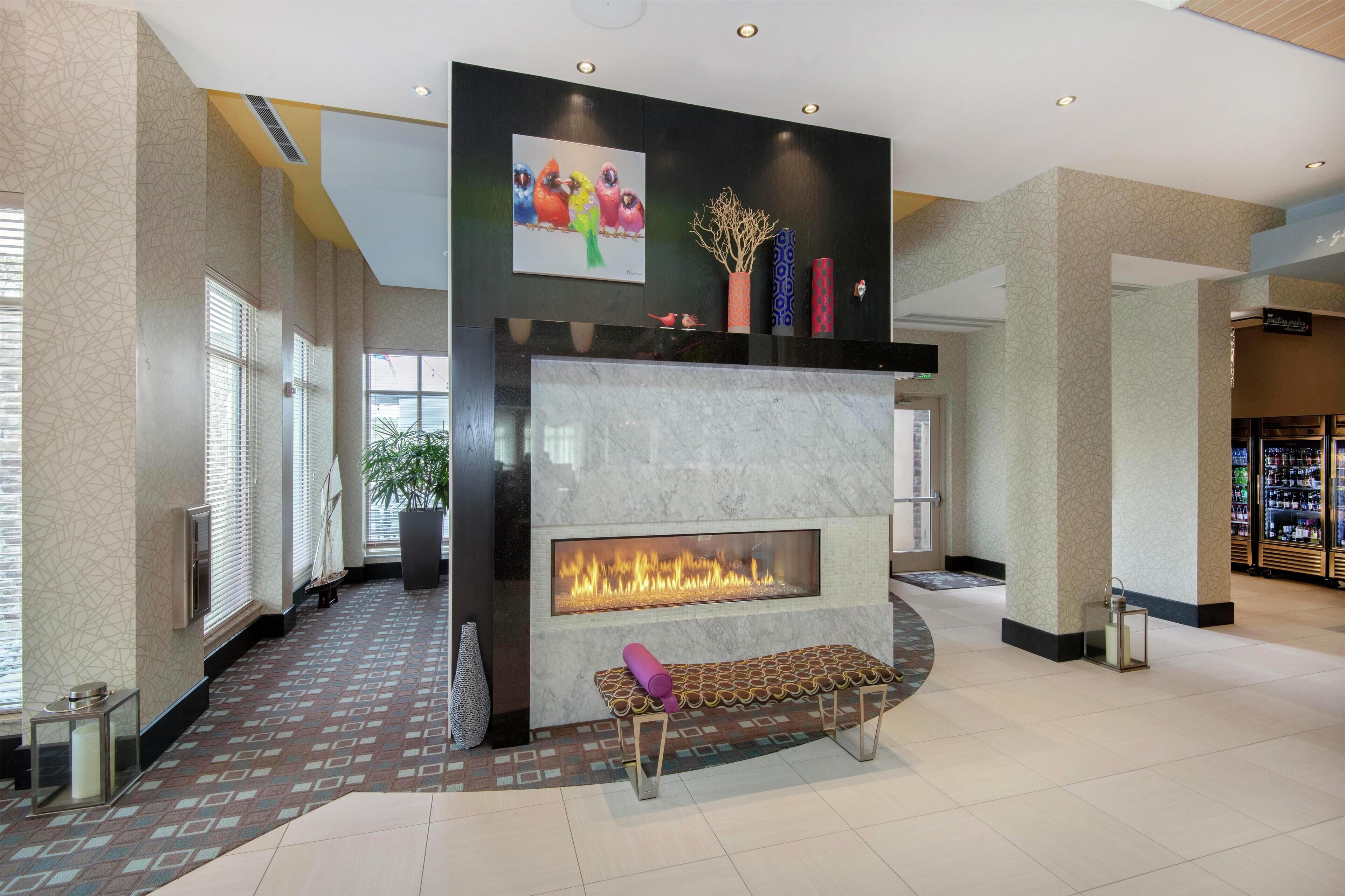 A lobby with a fireplace, a bench, and a reception desk.