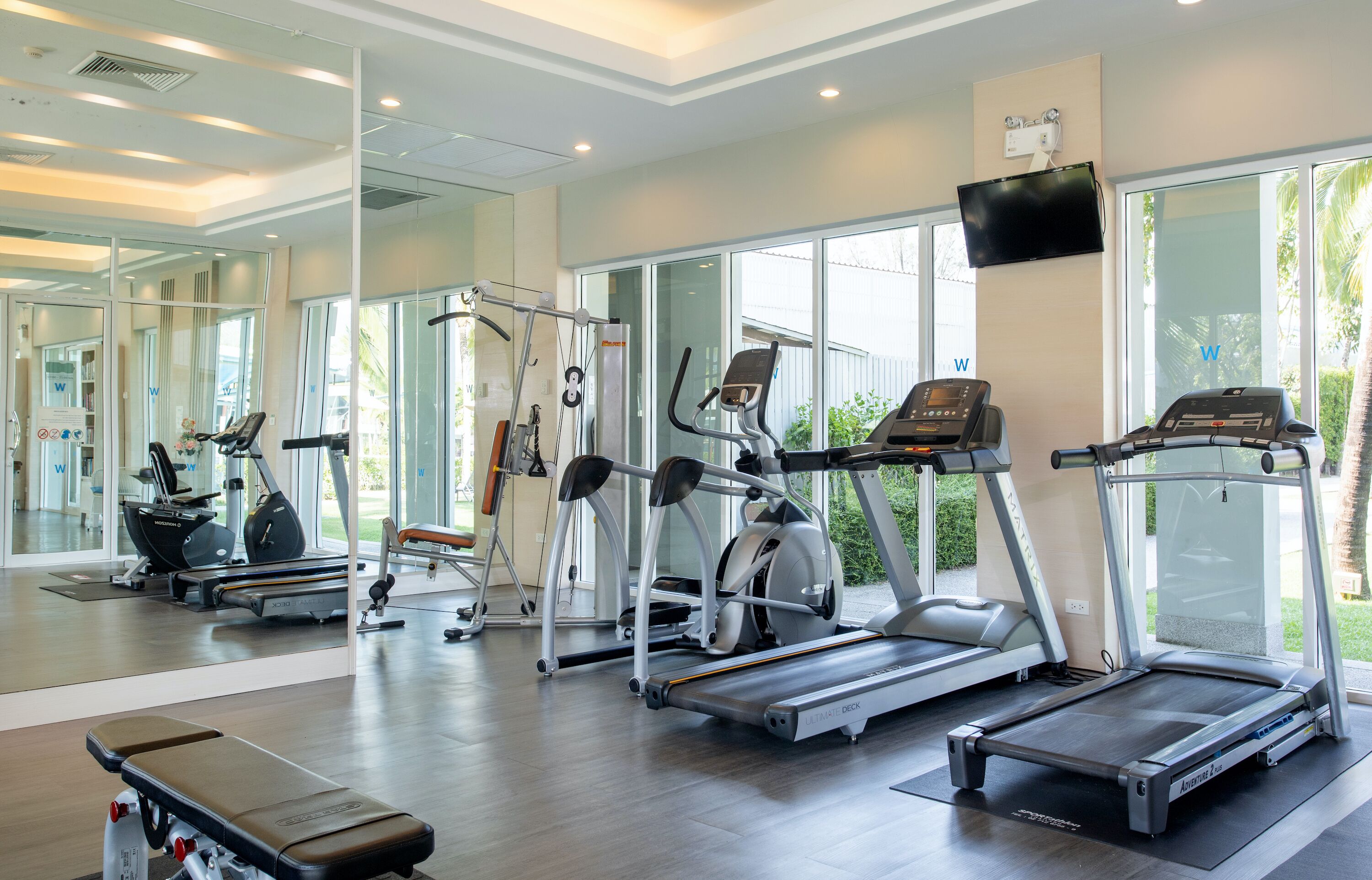 Una palestra con tapis roulant, ellittiche e macchinari per l'allenamento con i pesi.