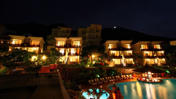 A multi-story hotel with balconies, a swimming pool, and well-lit outdoor areas. - Seaside Resort (Ho Chi Minh City)