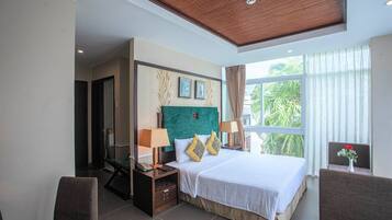 A hotel room with a large bed, two bedside tables with lamps, a chair, and a view of greenery through the window.
