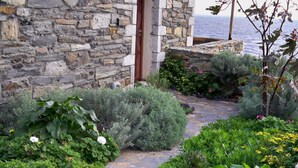 A stone building with a stone pathway leading to a wooden door.