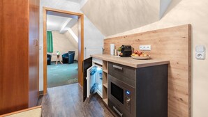 Una cocina compacta con horno integrado, una pequeña encimera y un respaldo de madera.