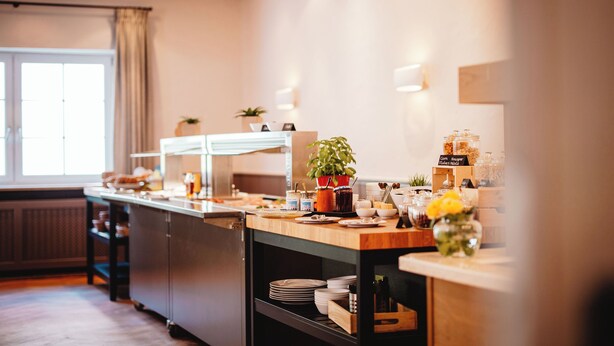 Una cocina moderna con encimera de madera, una cafetera y una planta en maceta.