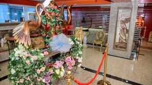 A reception area with a decorative floral arrangement, a statue of a swan, and a framed artwork on the wall. - Grand Pier Boutique Hotel (Bucharest)