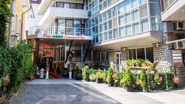 A modern hotel with multiple floors, large windows, and a central entrance with a red carpet. - Grand Pier Boutique Hotel (Bucharest)