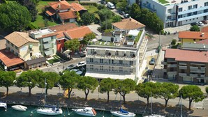 A coastal hotel with multiple floors, a rooftop terrace, and a marina with boats. - Hotel Acquadolce (Peschiera del Garda)