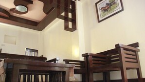 A room with a wooden dining table, chairs, a ceiling fan, and a framed picture on the wall. - Costa Villa Beach Resort (San Juan)