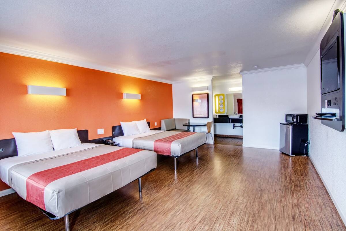 Habitación de hotel con dos camas, una kitchenette y un comedor.