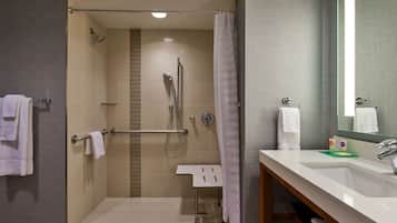 A modern bathroom with a shower, a sink, and a mirror.