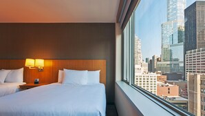 A hotel room with a large bed, two bedside lamps, and a city view through a large window. - Hyatt Place Chicago/River North (Chicago)