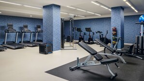 A gym with treadmills, weight machines, and a bench. - Hilton Garden Inn Atlanta Midtown (Atlanta)