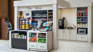 A self-service kiosk with a variety of packaged goods and beverages, a microwave, and a small refrigerator. - Hilton Garden Inn Atlanta Midtown (Atlanta)