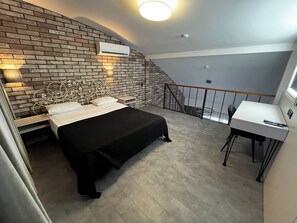 Ein Schlafzimmer mit einem Bett, einem Schreibtisch und einer Treppe.