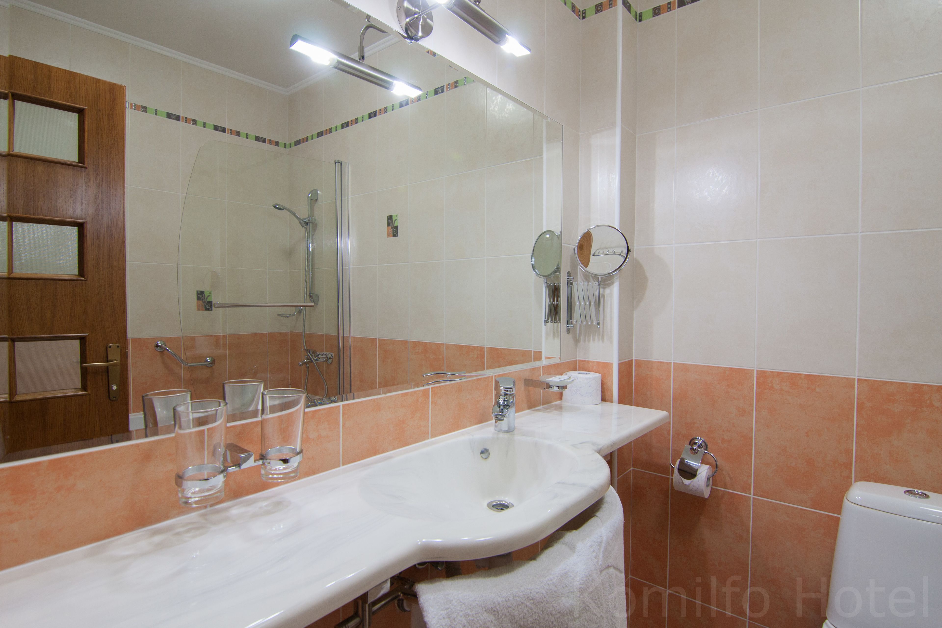 Un bagno con uno specchio grande, un lavandino e una doccia.