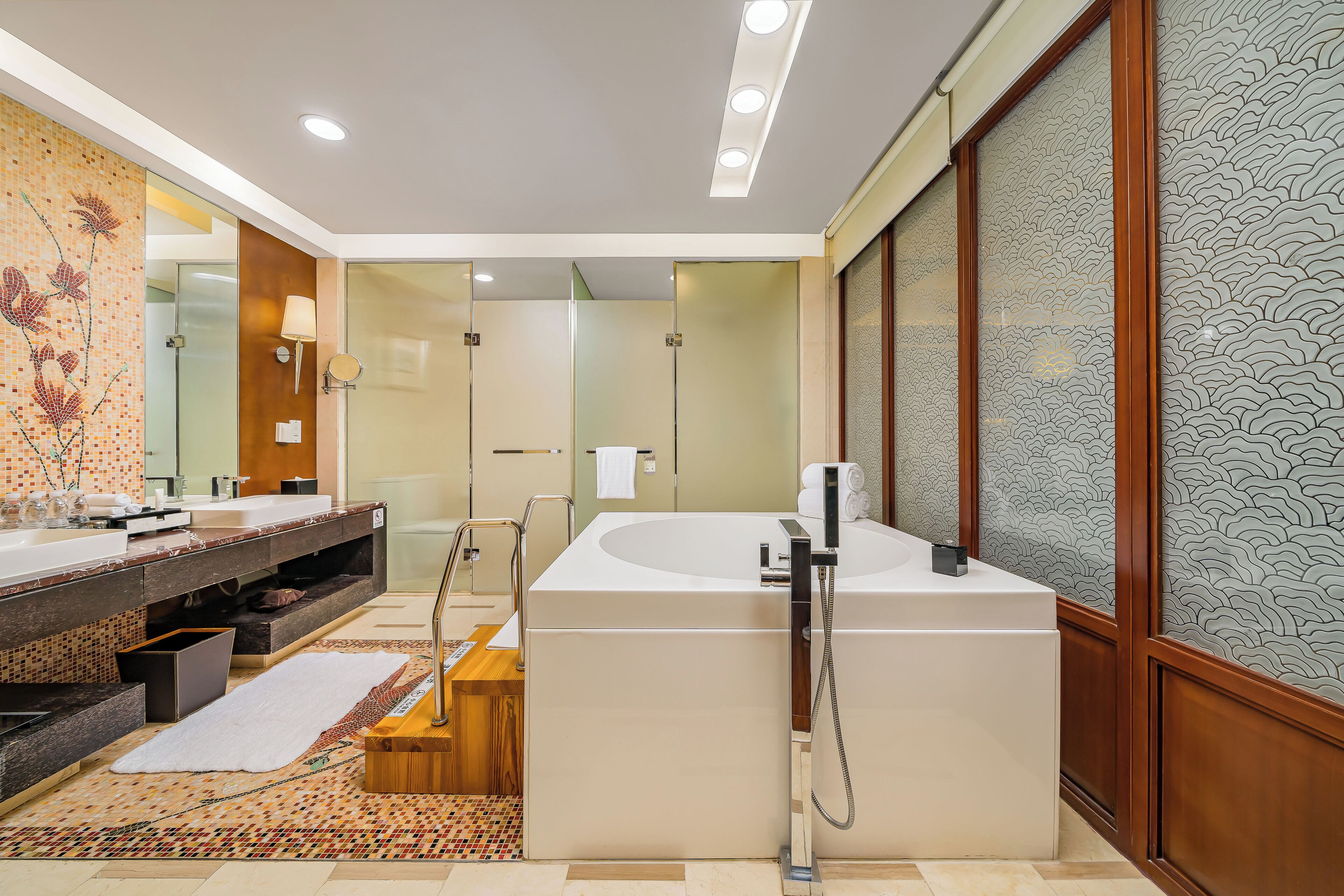 A modern bathroom with a large bathtub, a double vanity with a mirror, and a shower area.