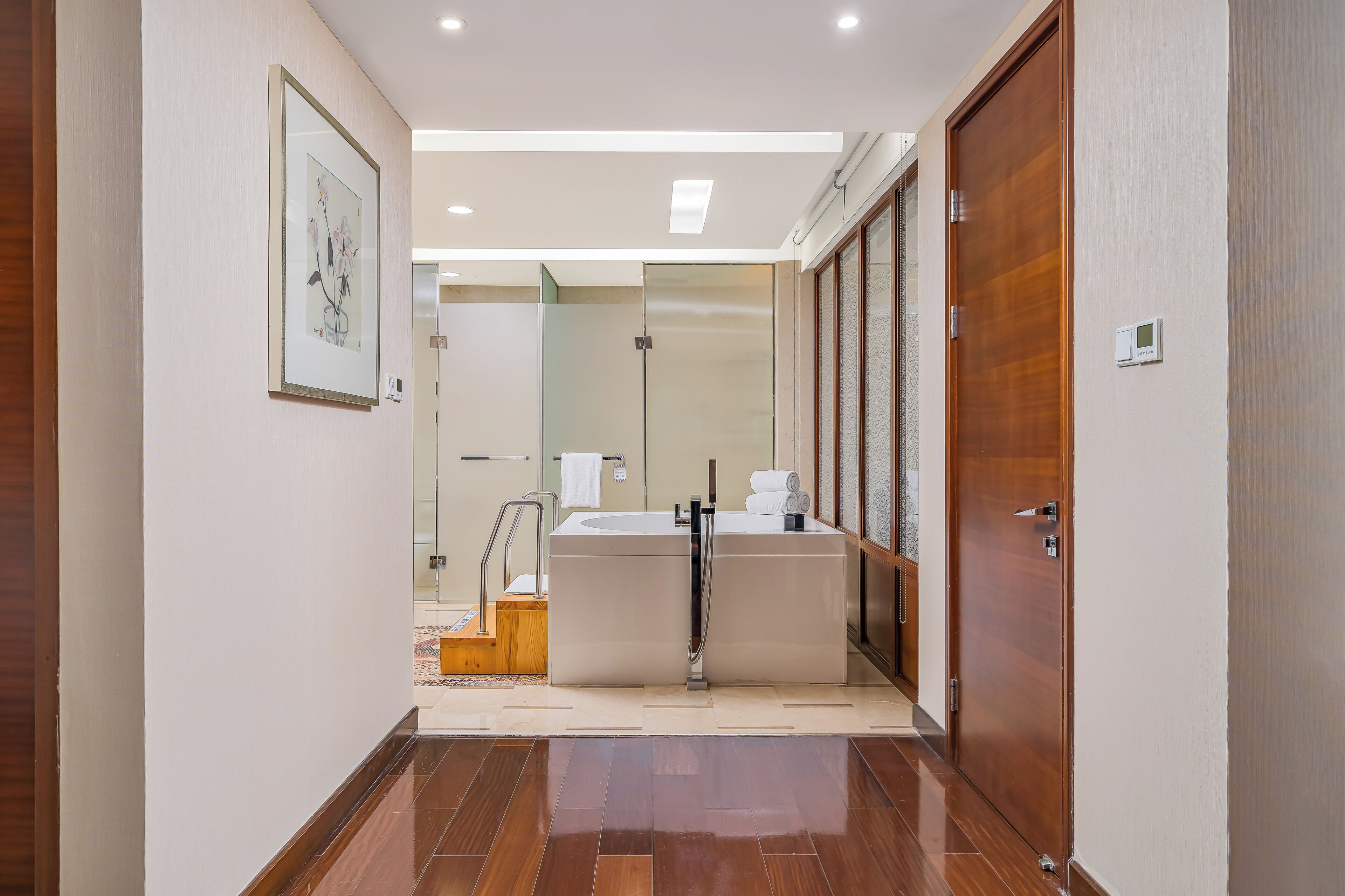 A modern bathroom with a large bathtub, a shower, and a glass-enclosed shower area.