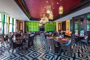 Un ristorante con pavimento a scacchi, diversi tavoli e sedie.