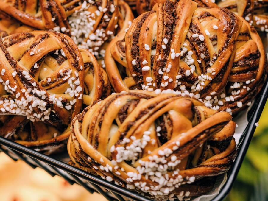 Eine Schale Zimtschnecken mit weißem Zucker bestreut.