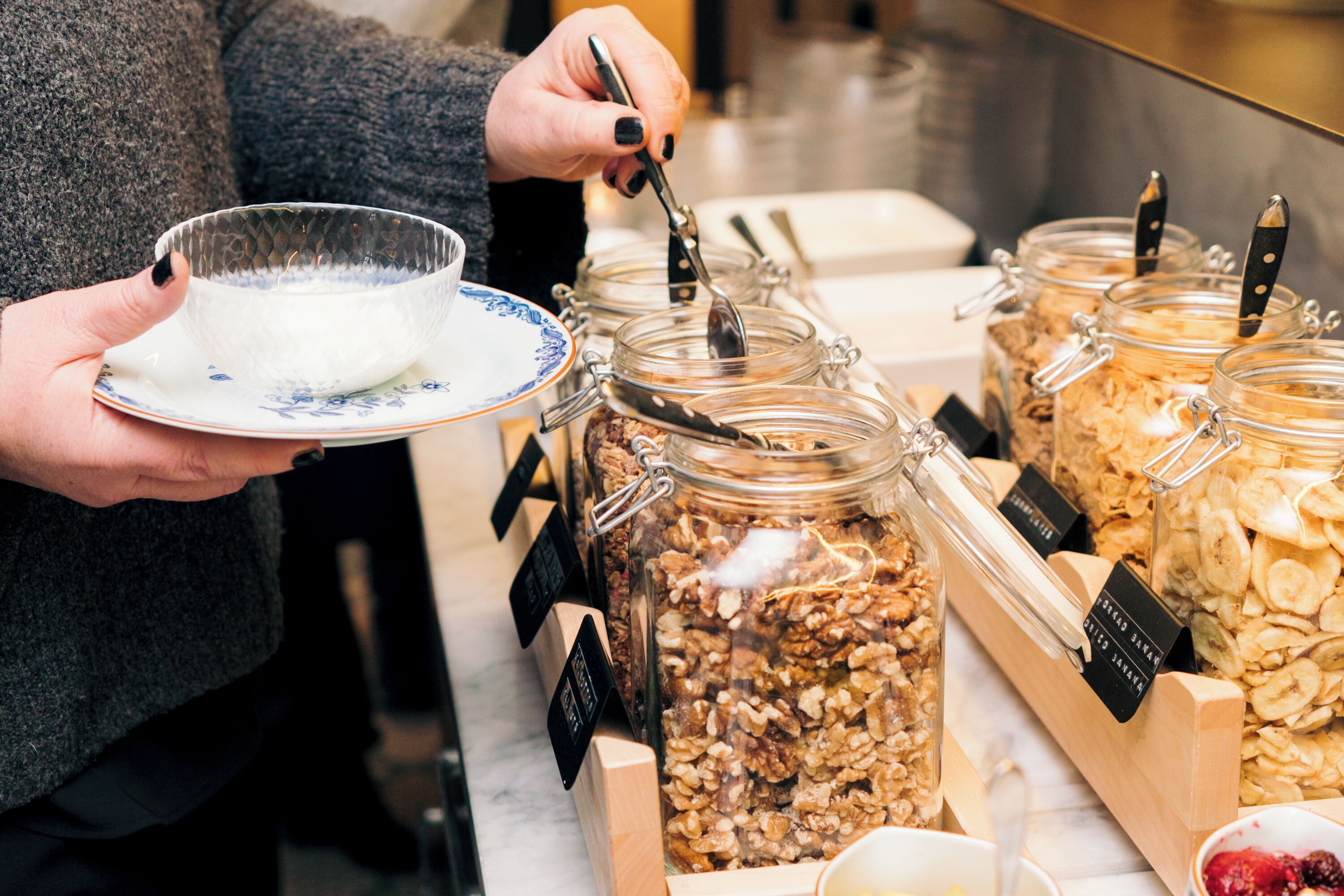 Una persona triant granola d'una presentació de diferents barres de granola.