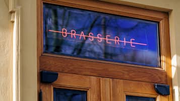 A wooden door with a neon sign that reads "BRASSERIE".